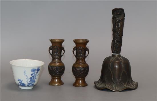 A Chinese bronze bell, a pair of miniature bronze vases and a blue and white cup with Kangxi mark tallest 15cm